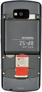 Take hold of the top of the battery and remove it.